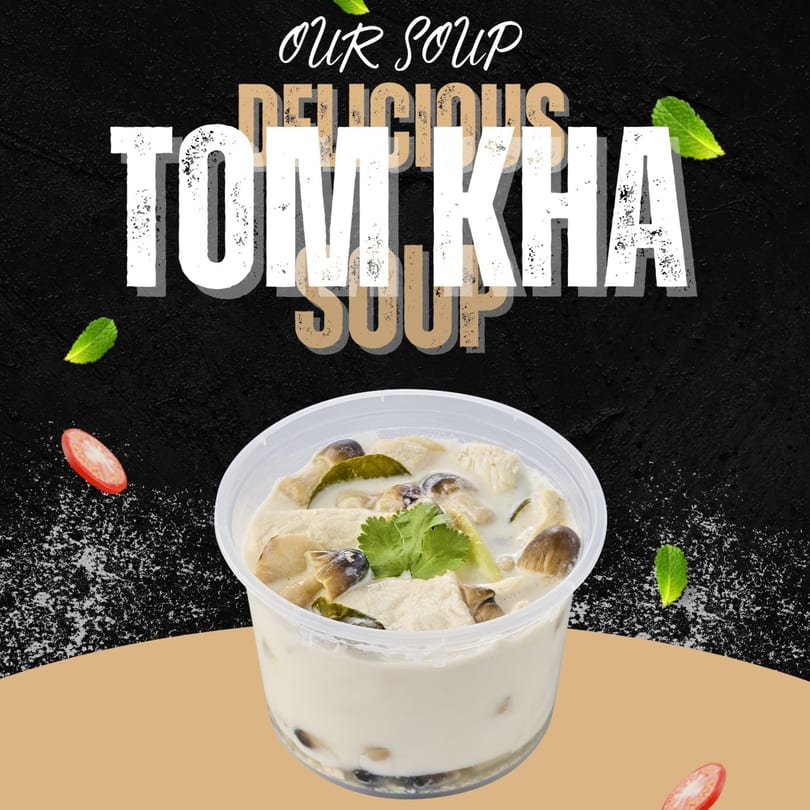 Creamy Tom Kha soup with mushrooms and chicken in a clear plastic container.